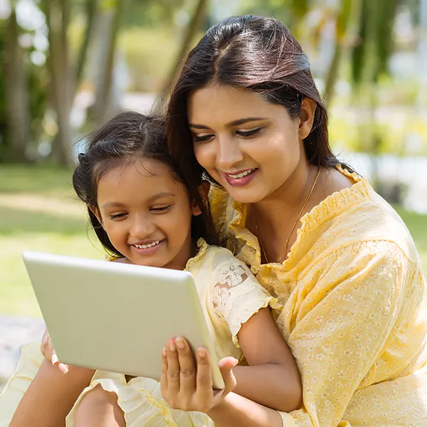 mother with child on tablet outdoors
