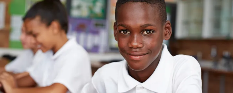 student at desk looking at viewer