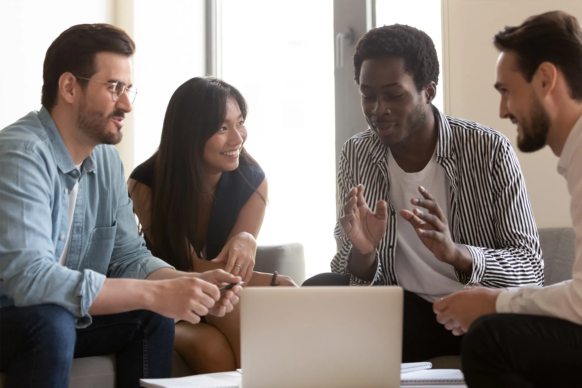 professionals having a discussion in front of a laptop