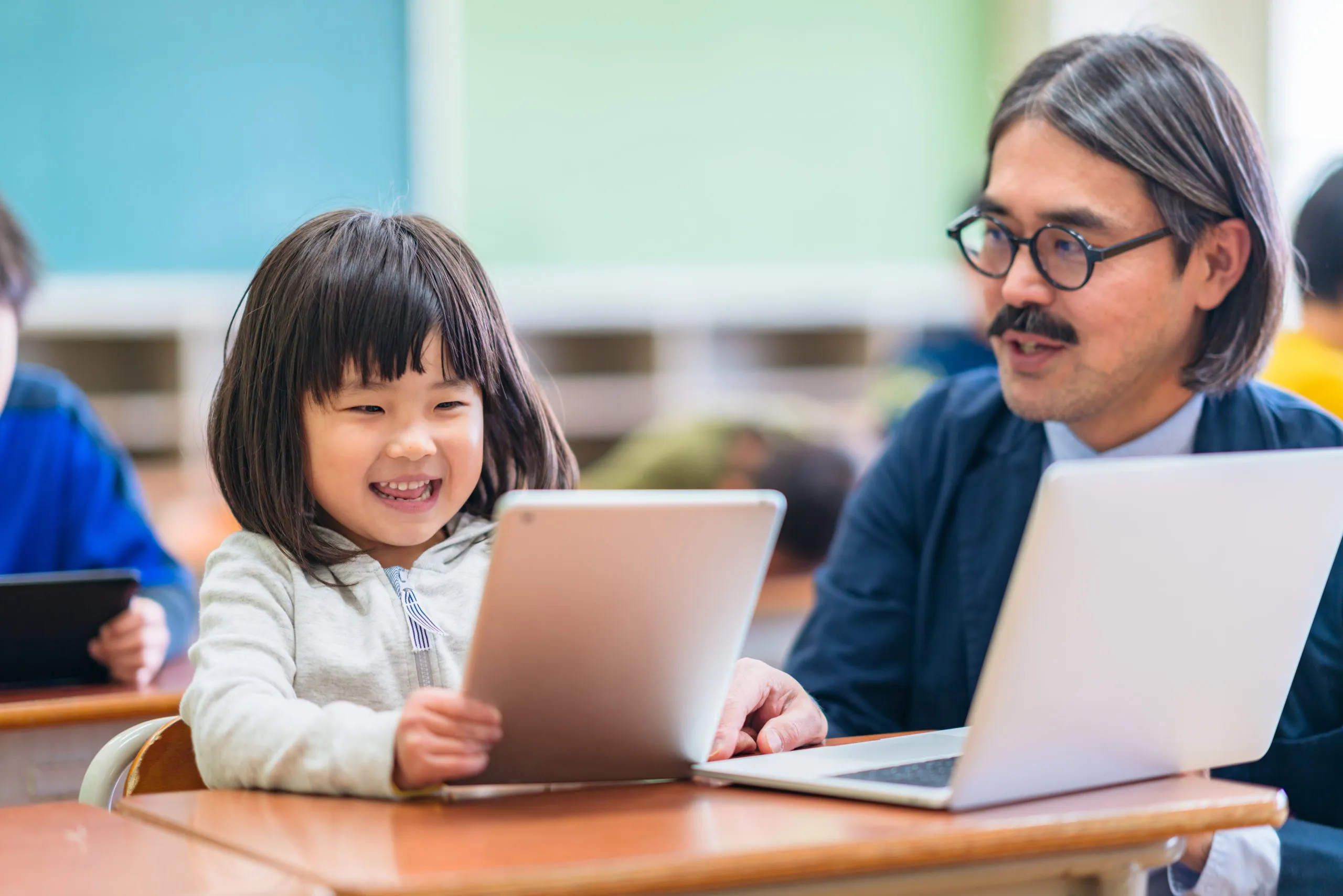 Male teacher teaching technology in elementary school in classroom