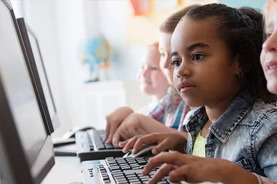 row of kids on desktop computers