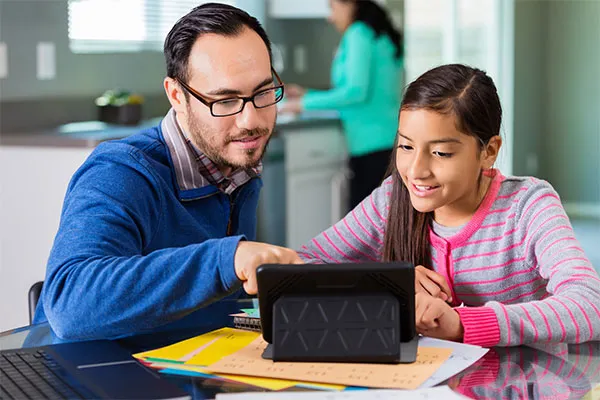 teacher helping student on her laptop