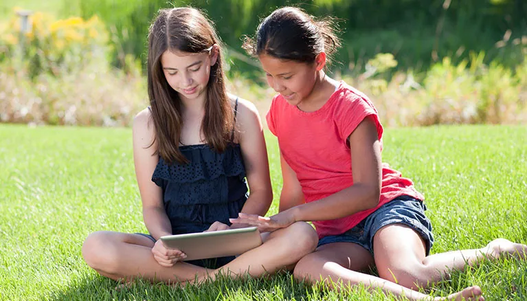 kids studying outside in the grass