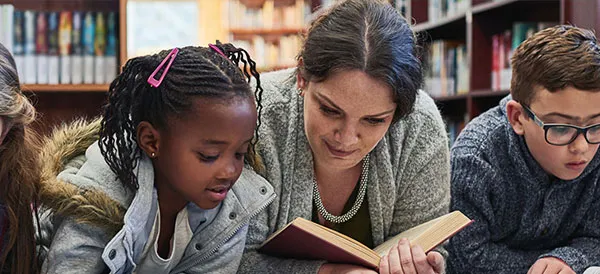 teacher reading book with student