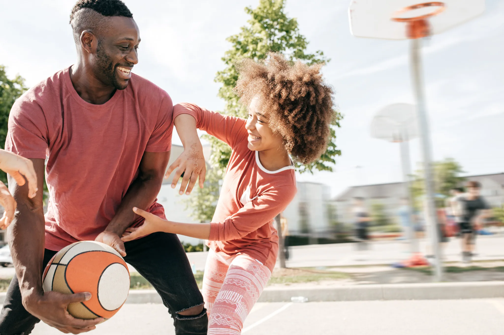 father playing basketball with a young girl