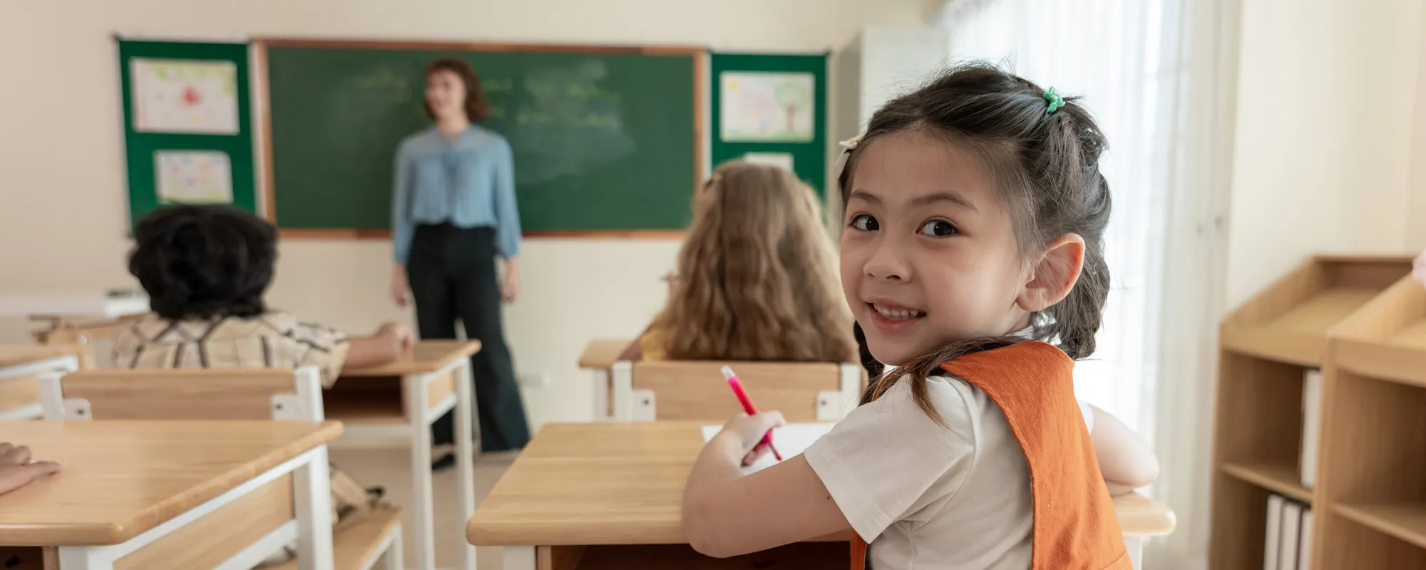 young girl looking back while at desk