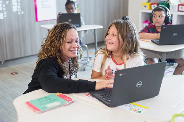 A teacher and a student with a laptop